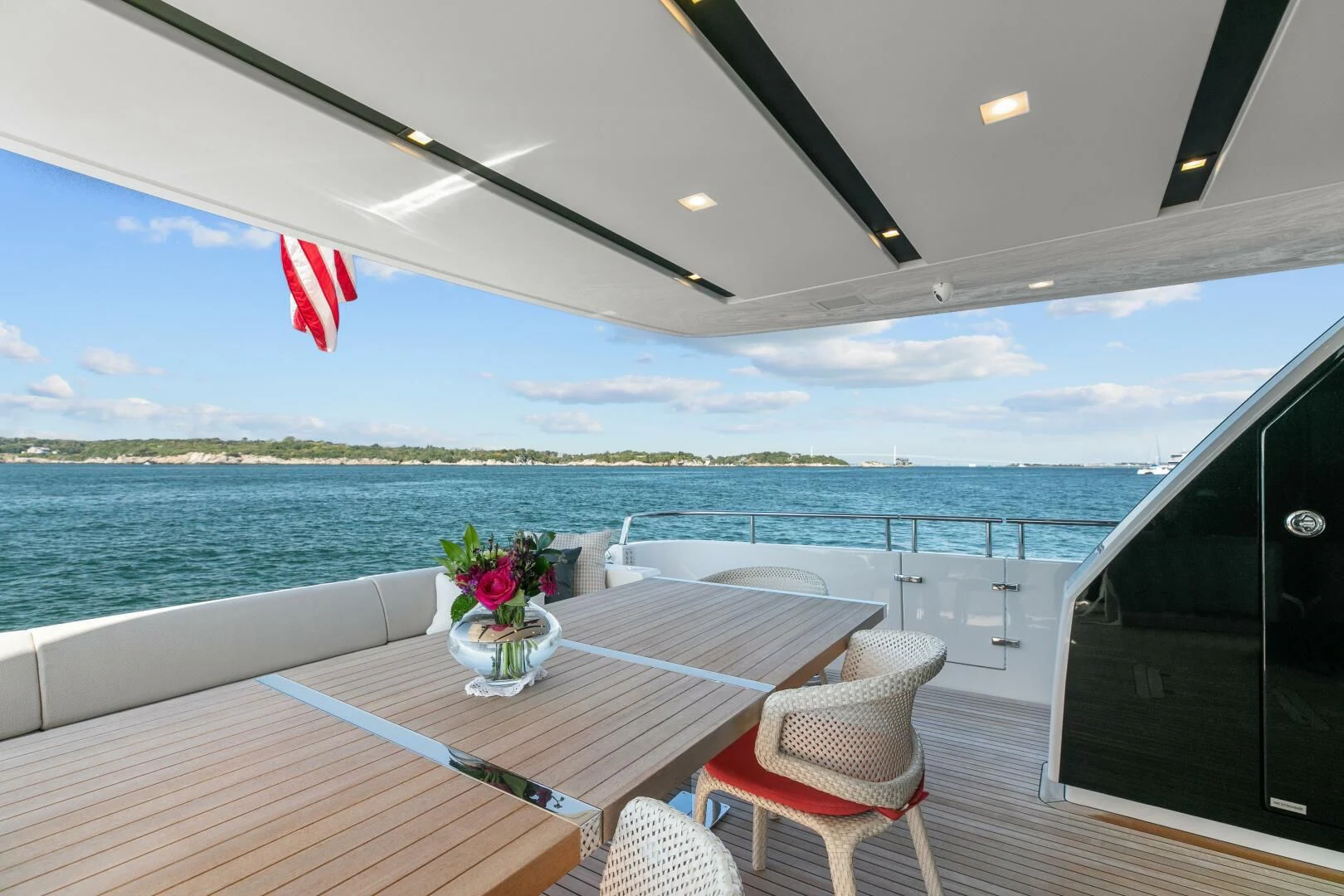 a table and chairs on a deck overlooking a body of water aboard JUJU Yacht for Sale