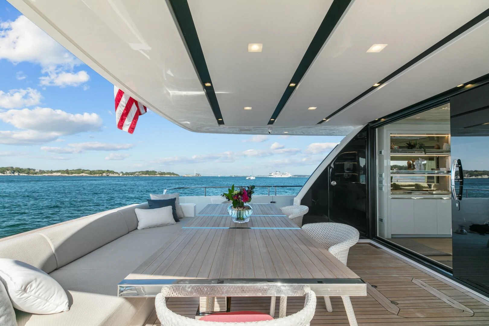 a deck with chairs and a body of water in the background aboard JUJU Yacht for Sale