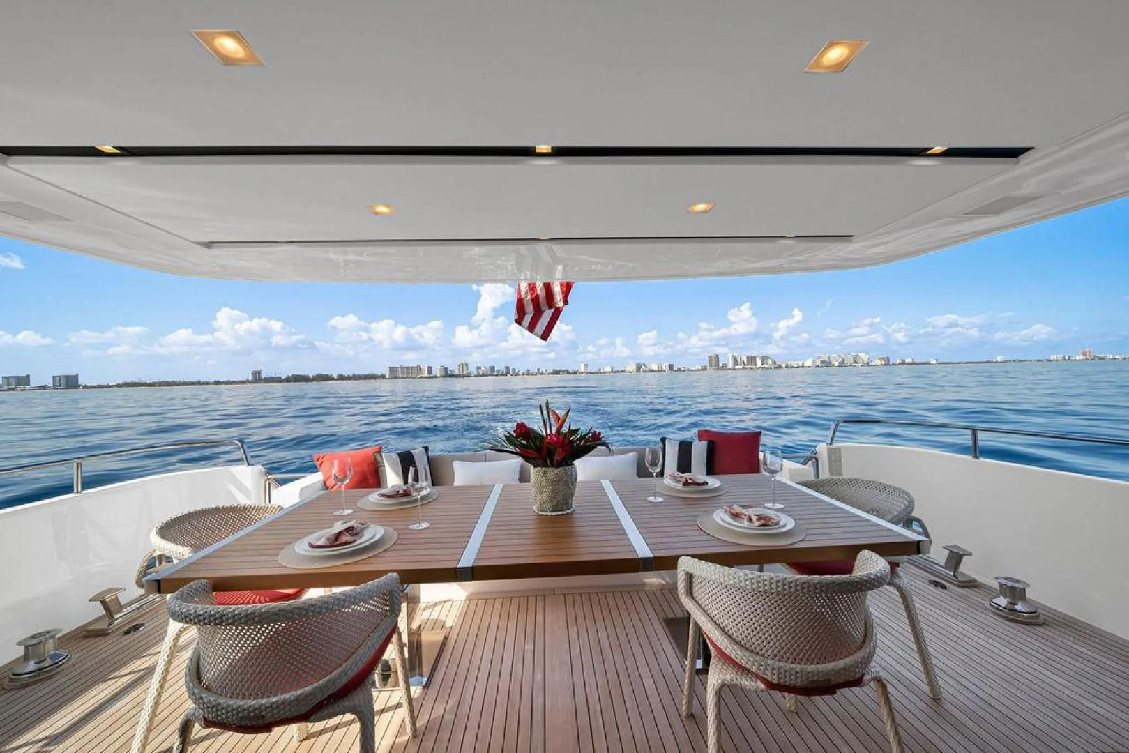a table set for a meal on a deck overlooking a large body of water aboard JUJU Yacht for Sale