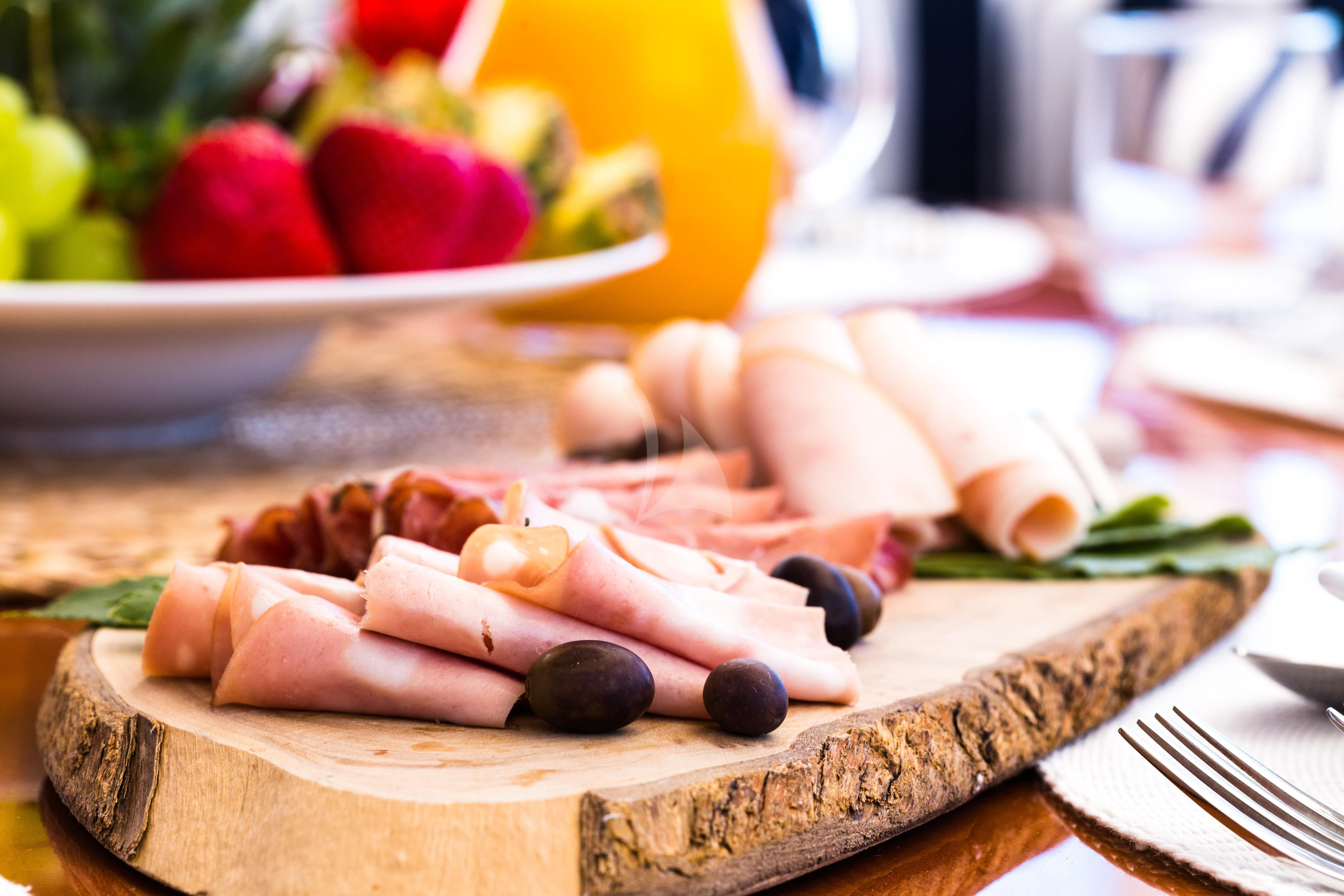 a person's hand holding a knife next to a plate of food aboard STAR OF THE SEA Yacht for Sale