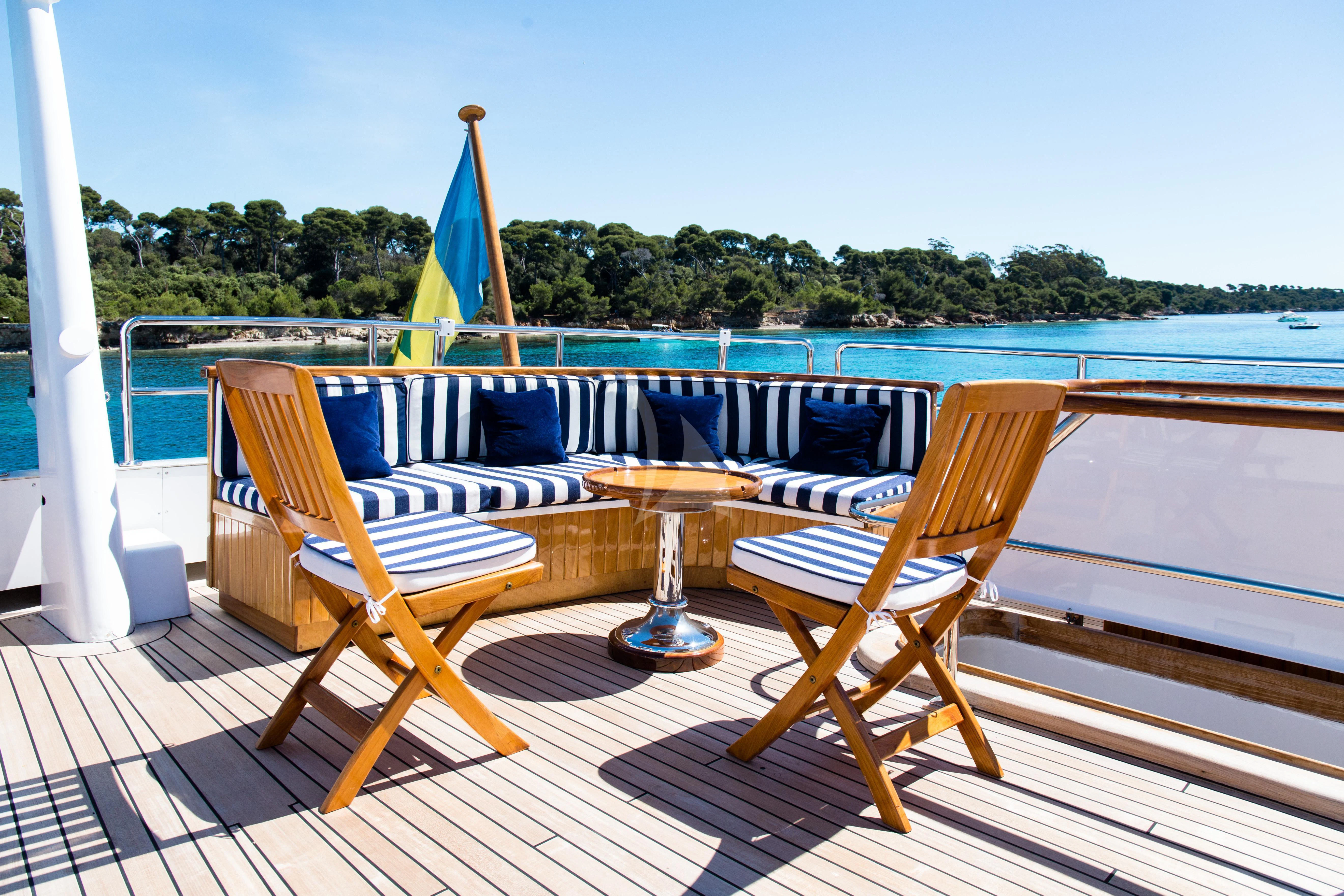 a table and chairs on a deck overlooking a body of water aboard STAR OF THE SEA Yacht for Sale