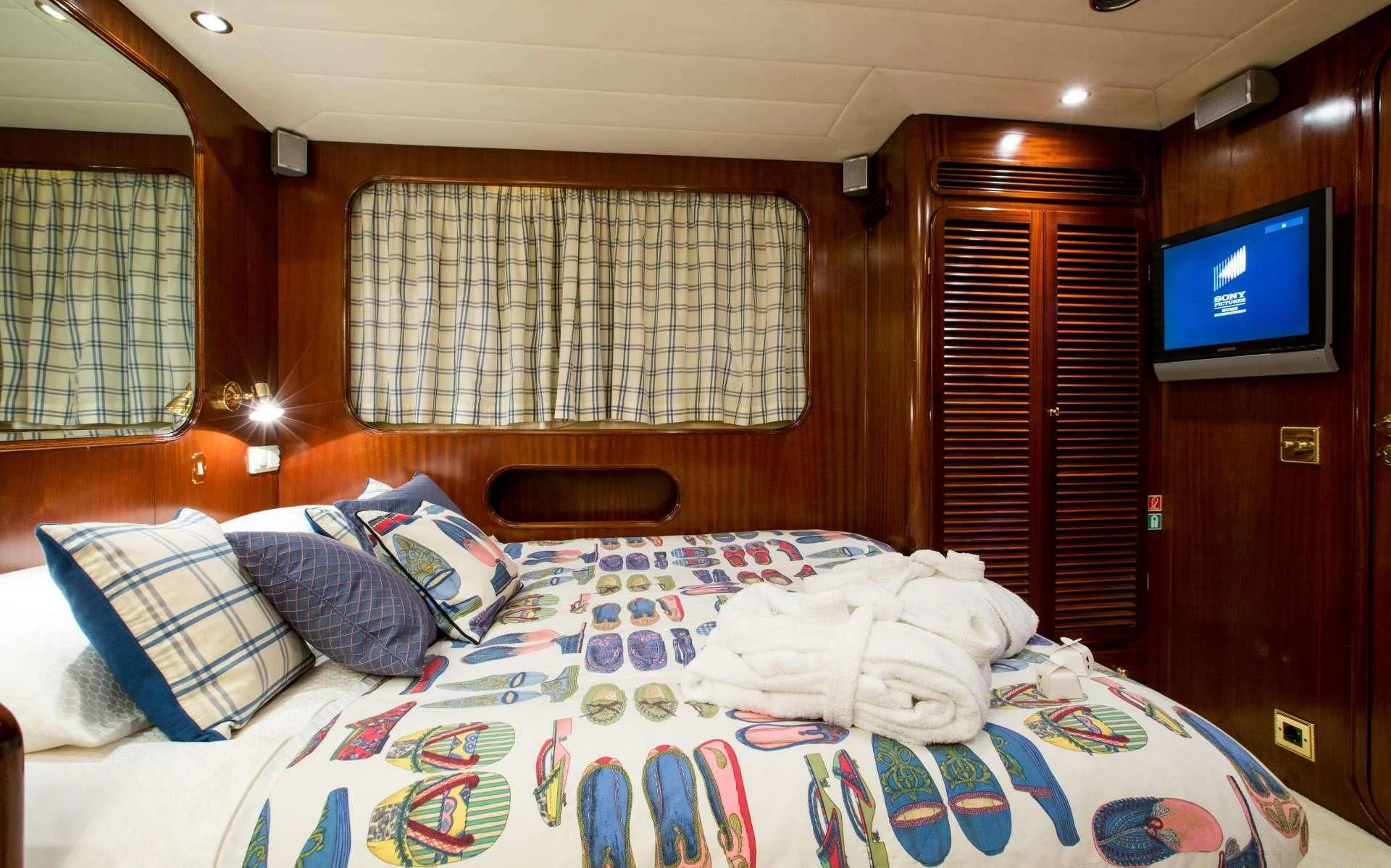 a bed with a television on the wall aboard STAR OF THE SEA Yacht for Sale