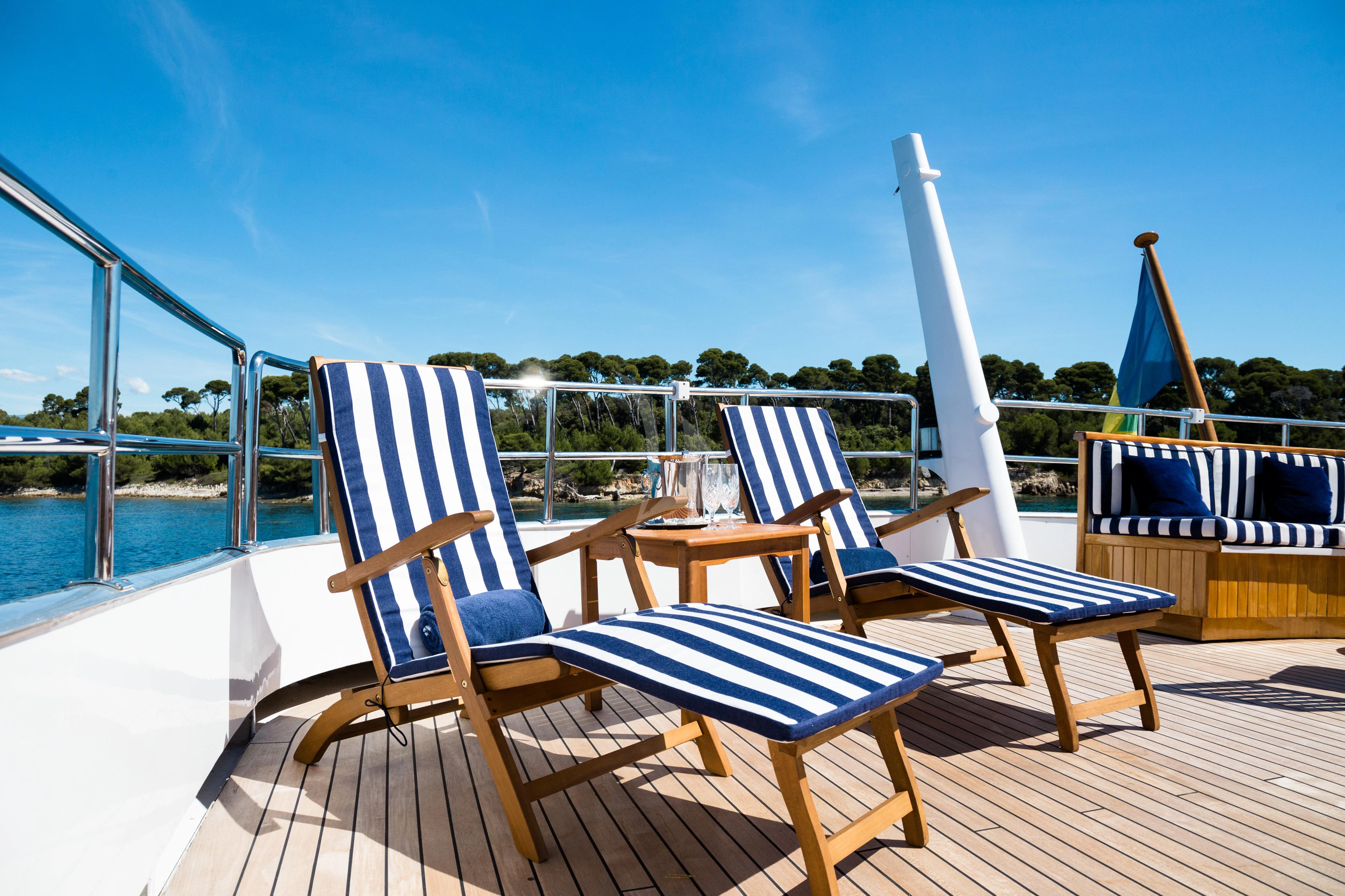 a deck with chairs and a table aboard STAR OF THE SEA Yacht for Sale