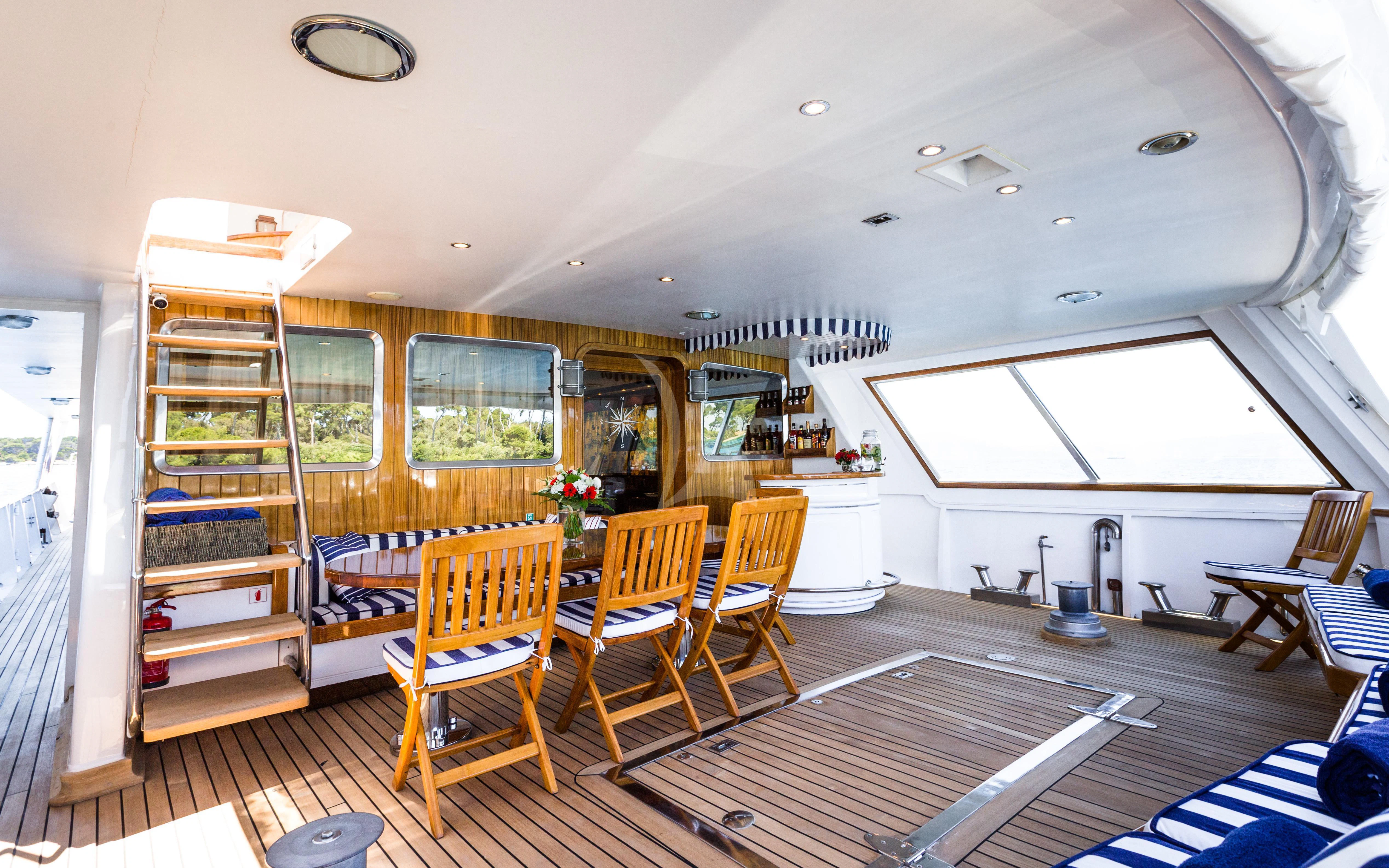a room with a wood floor and a shelf with books on it aboard STAR OF THE SEA Yacht for Sale