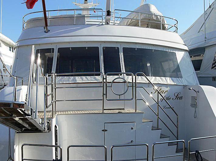 a white boat with a flag on the front aboard STAR OF THE SEA Yacht for Sale