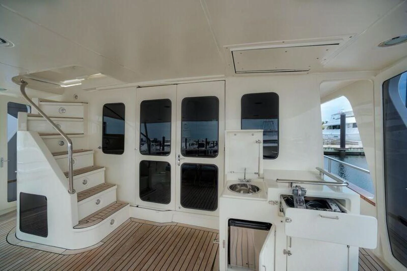 a white kitchen with a staircase aboard GRACIE Yacht for Sale