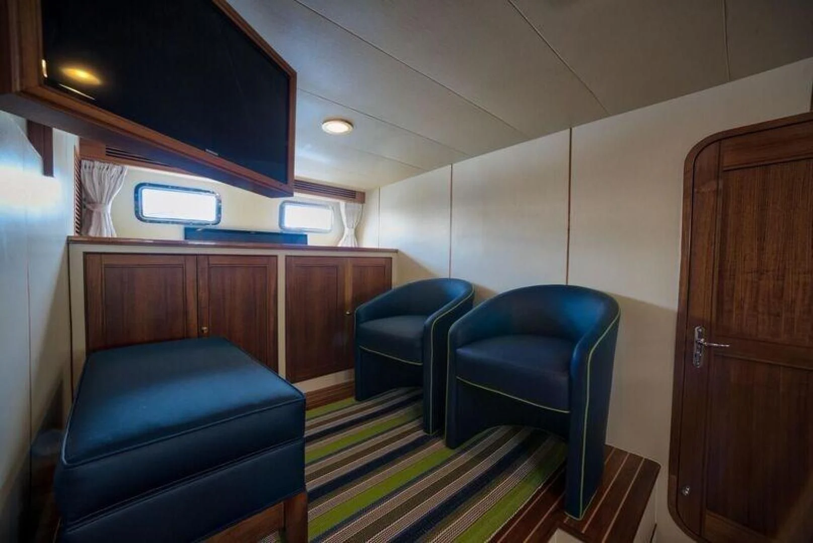 a room with chairs and a television aboard GRACIE Yacht for Sale