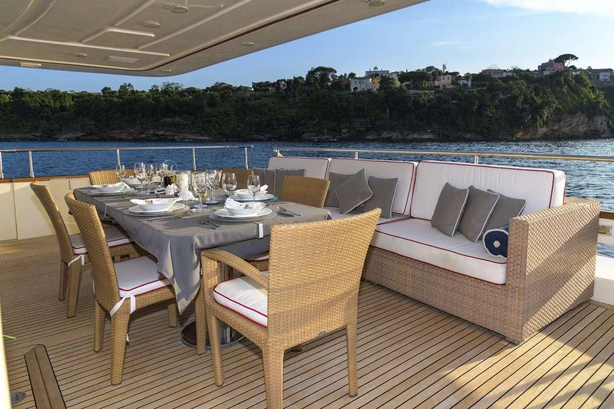 a table set for a meal on a deck overlooking a body of water aboard ANNE MARIE Yacht for Sale