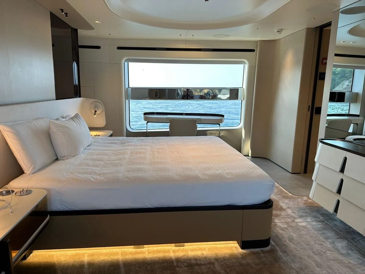 a bed with a large window aboard NG Yacht for Sale