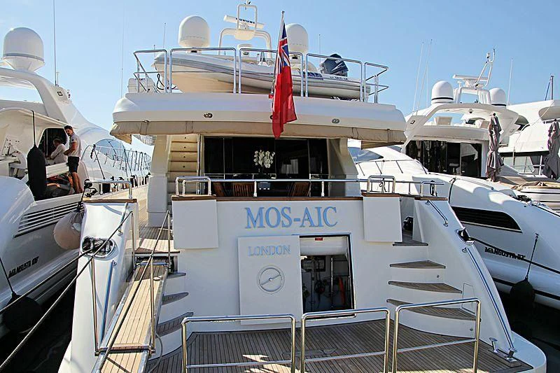 a boat with a flag on the front aboard MOS-AIC Yacht for Sale