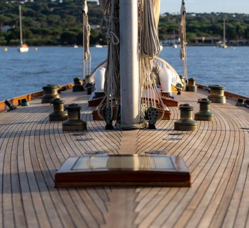 a wooden deck with a large white column and a body of water in the background aboard SAVANNAH Yacht for Sale