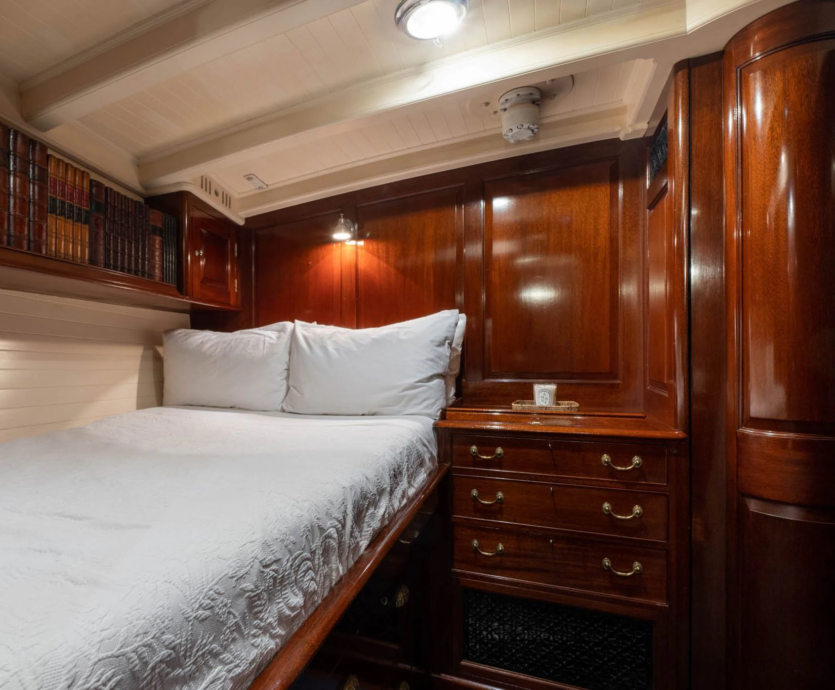 a bed with a wooden headboard aboard SAVANNAH Yacht for Sale