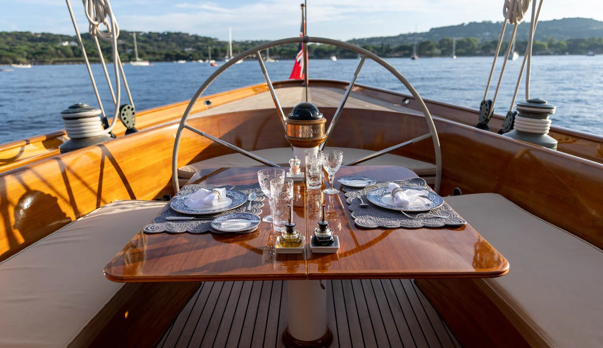 a wooden boat with a table and plates on it aboard SAVANNAH Yacht for Sale