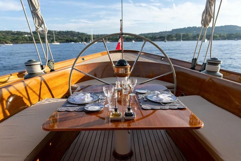 a table with plates and a fishing pole on it aboard SAVANNAH Yacht for Sale