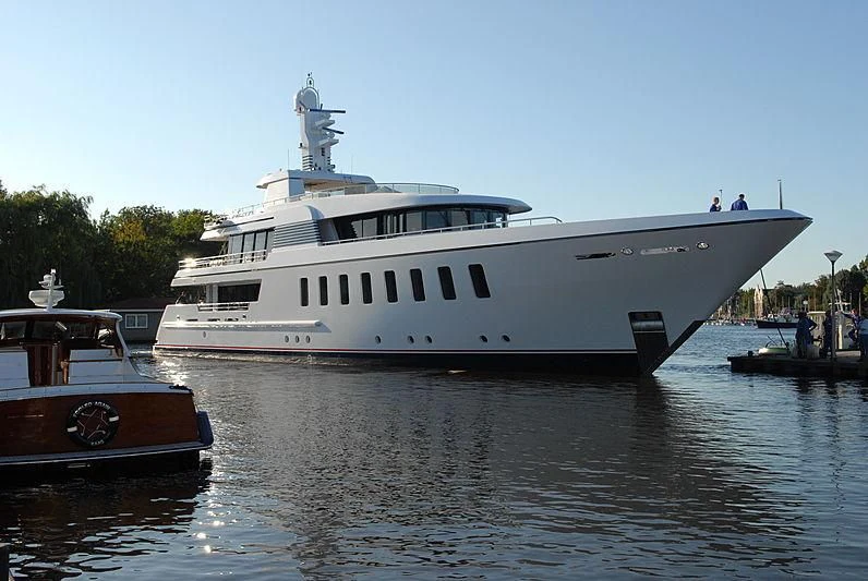 a large white boat docked next to a smaller boat aboard MEGAN Yacht for Sale