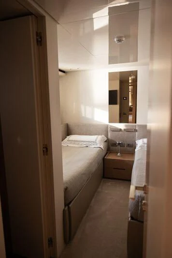 a small bedroom with a mirror aboard AMIGA Yacht for Sale