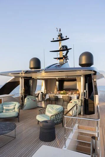 a balcony with a table and chairs aboard AMIGA Yacht for Sale