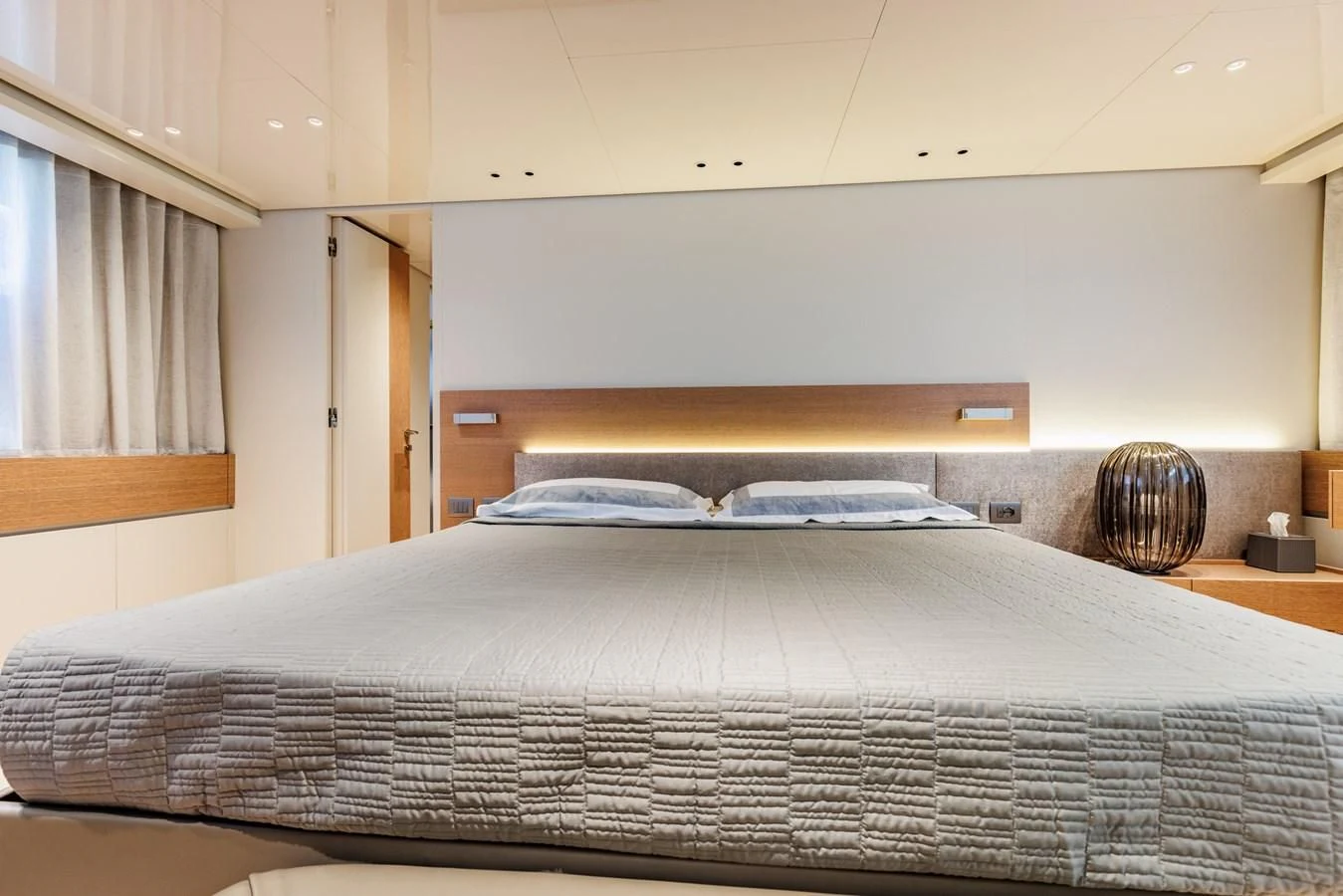 a bed with a black headboard aboard AMIGA Yacht for Sale