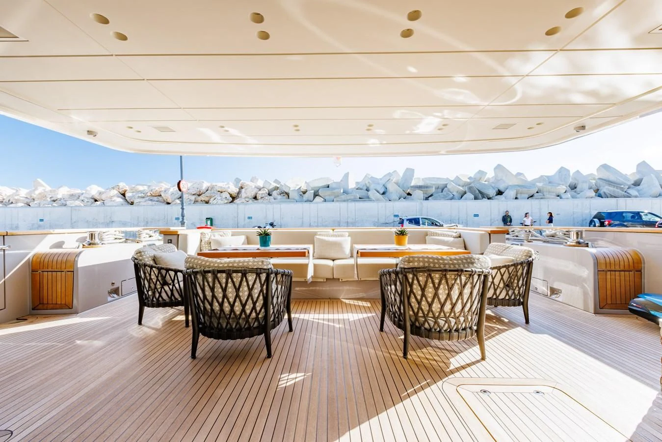 a room with a table chairs and a large pool in the background aboard AMIGA Yacht for Sale