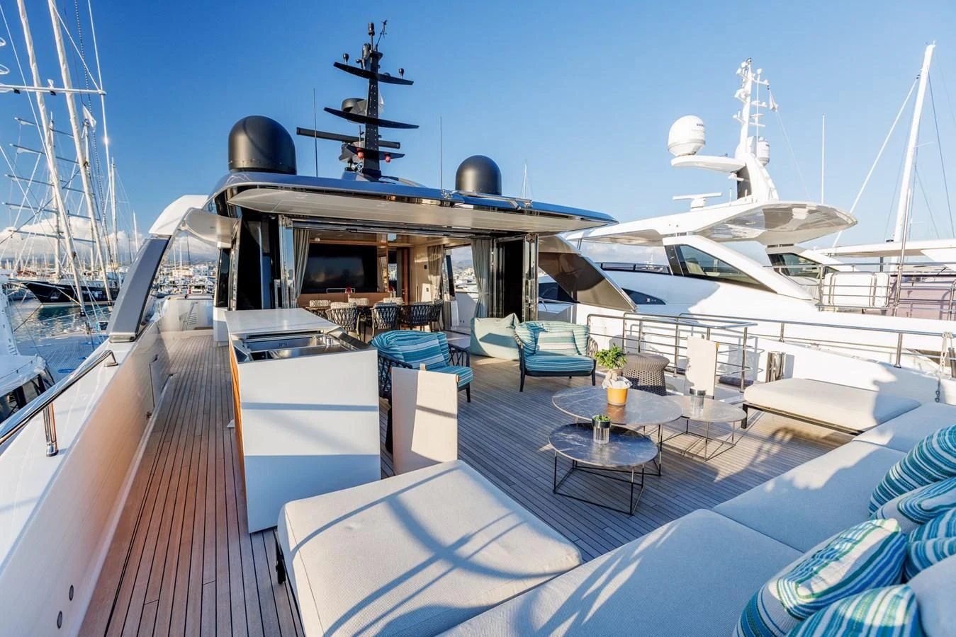 a deck with a boat and a table with chairs on it aboard AMIGA Yacht for Sale