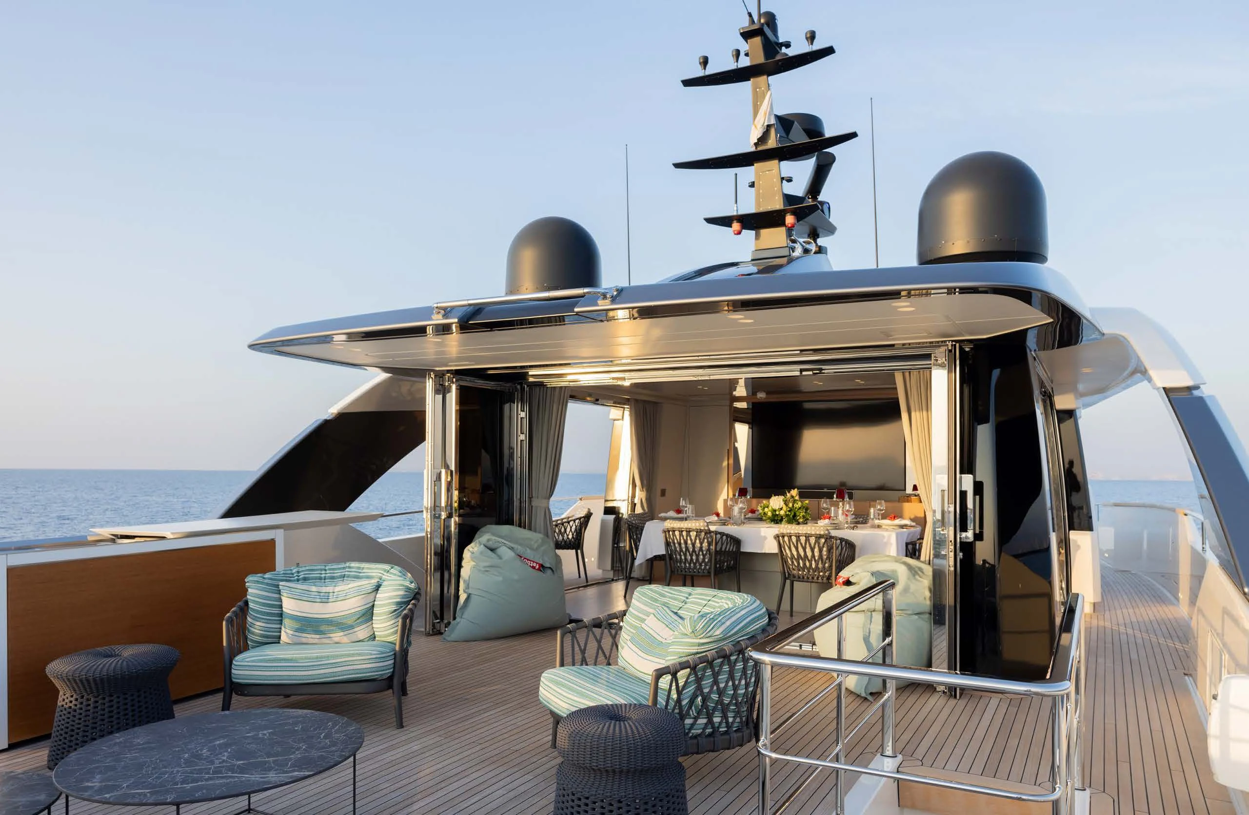 a deck with a table and chairs on it aboard AMIGA Yacht for Sale
