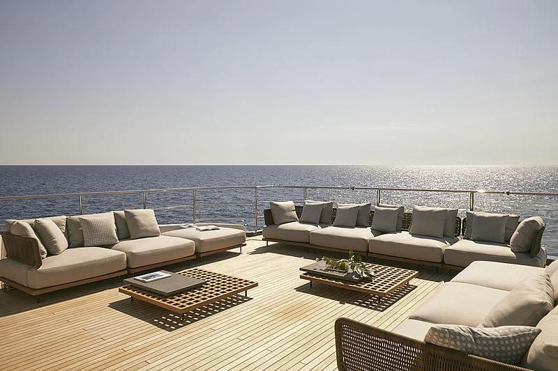 a living room with a large body of water in the background aboard ANURAG Yacht for Sale