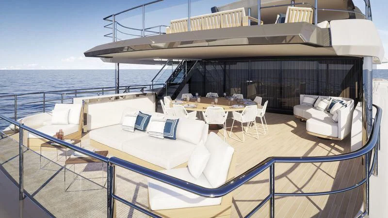 a large white lounge chair on a deck with a large white table and white chairs on a boat aboard ANURAG Yacht for Sale