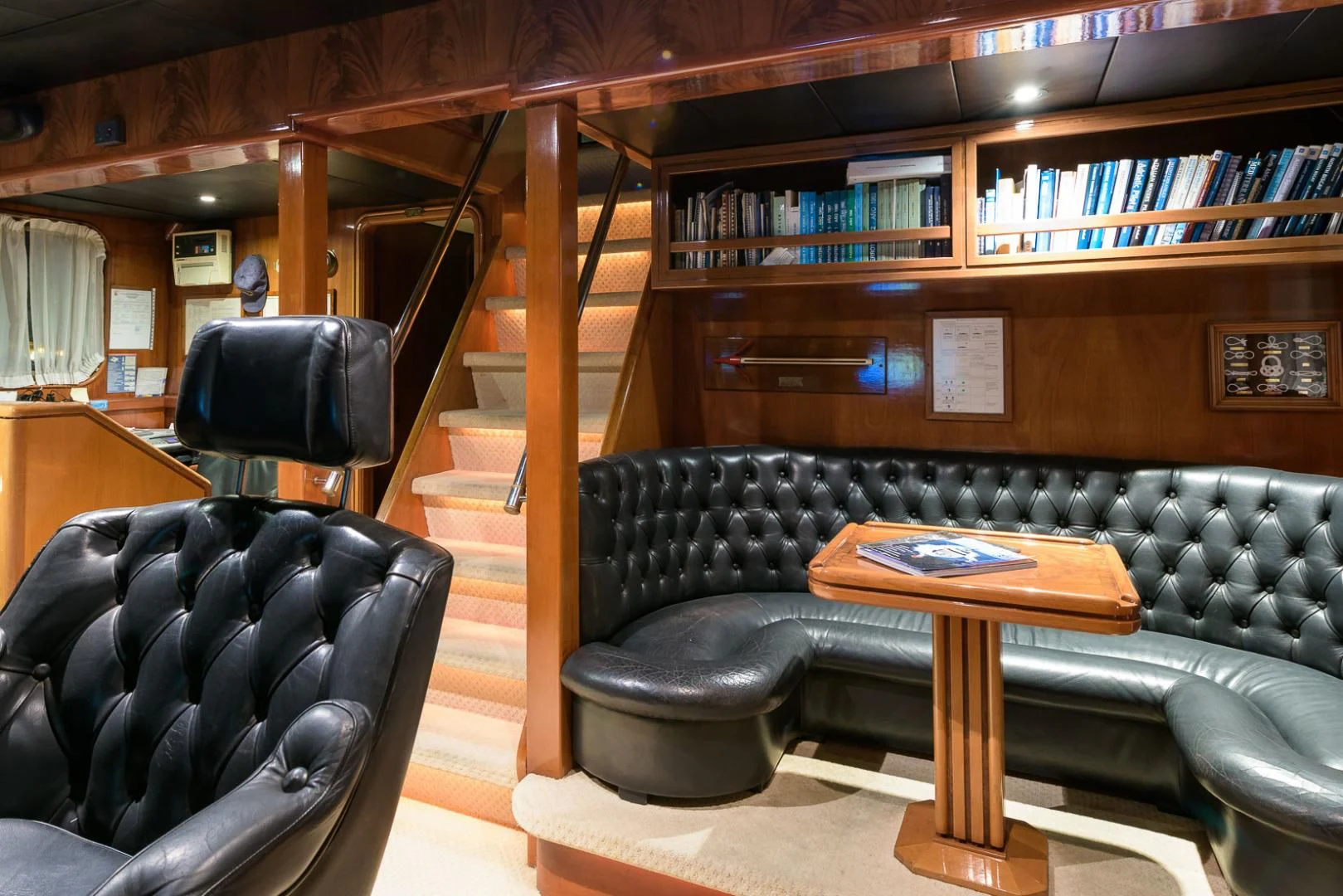 a leather couch in a library aboard ELBA Yacht for Sale