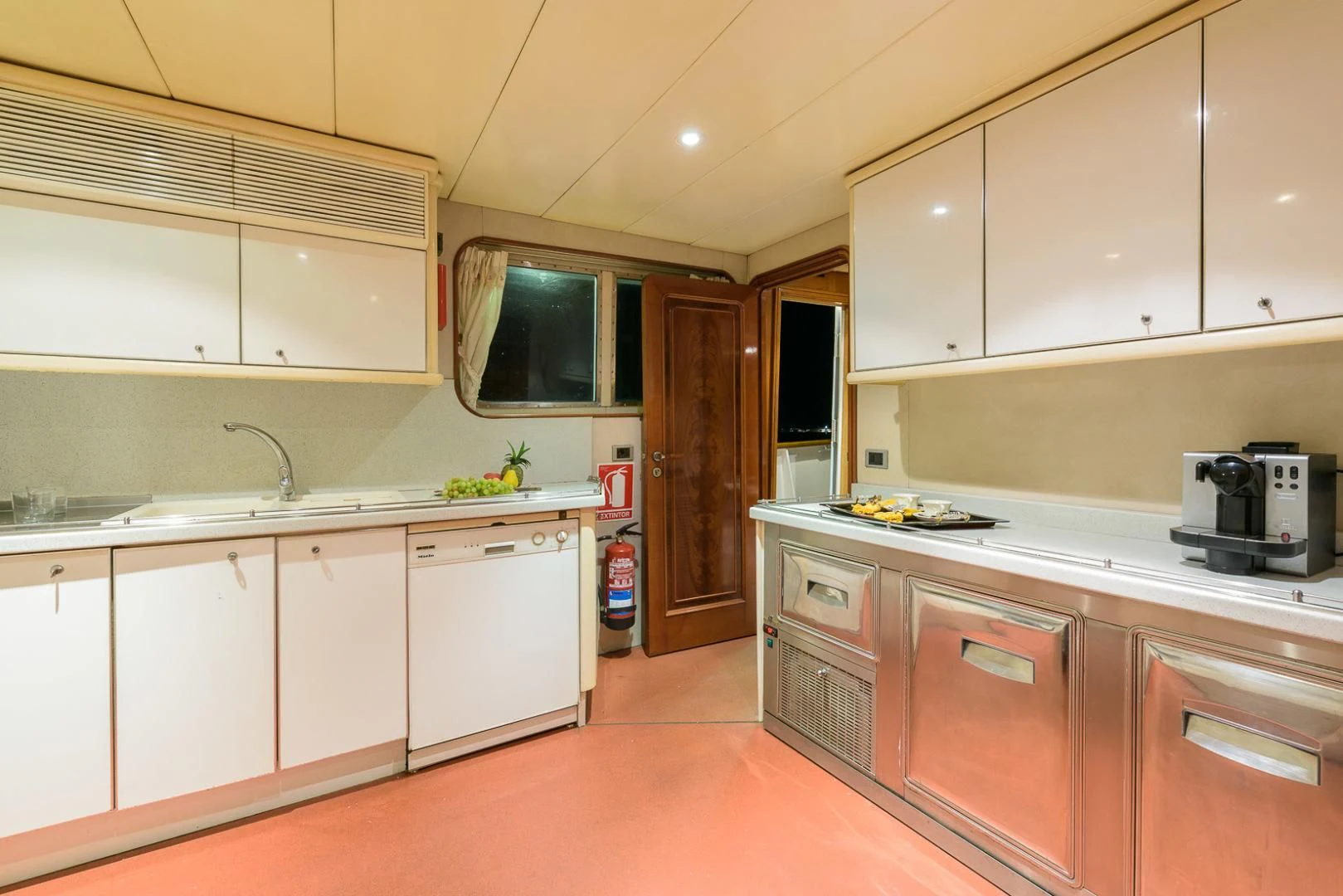 a kitchen with white cabinets aboard ELBA Yacht for Sale