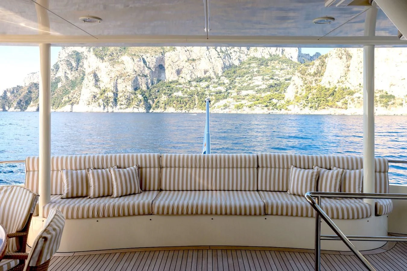 a couch and chairs on a deck overlooking a lake aboard LIBERTA Yacht for Sale