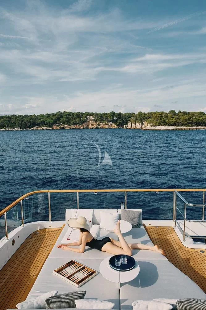 a person lying on a lounge chair on a boat aboard LEGEND Yacht for Sale