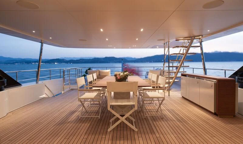 a room with a table and chairs on a deck aboard LEGEND Yacht for Sale
