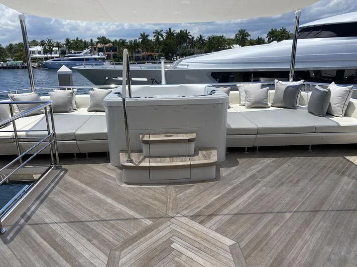 a deck with a couple of white lounge chairs and a white couch with a white railing and trees aboard CHILLAXIN' Yacht for Sale