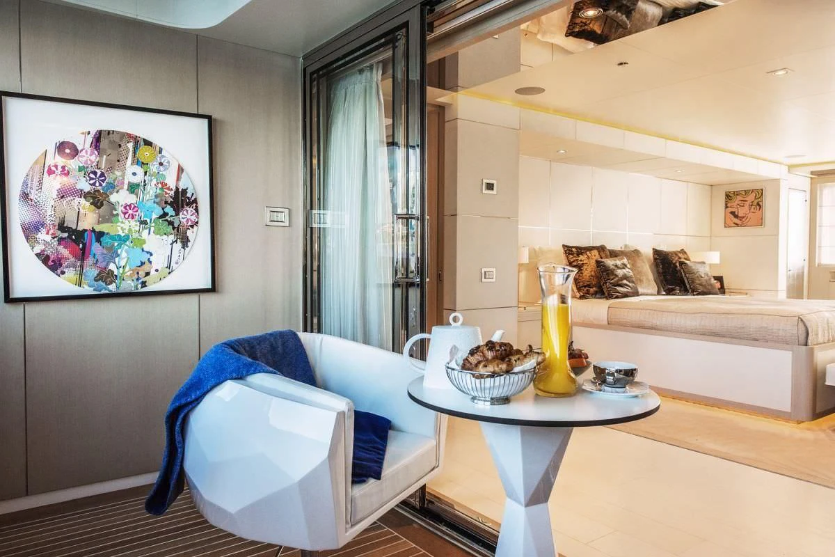 a living room with a blue chair and a white table aboard ELENI Yacht for Sale