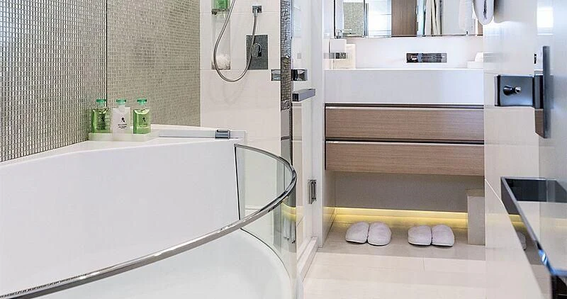 a white bathtub with a sink and a shelf with bottles aboard ELENI Yacht for Sale