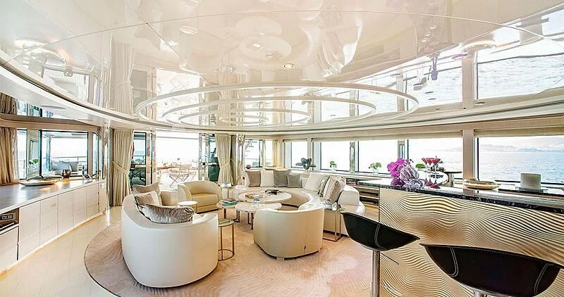 a room with tables chairs and a large window aboard ELENI Yacht for Sale