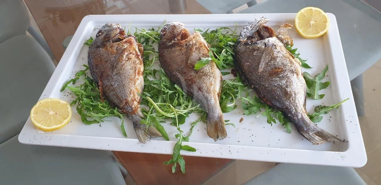 a plate of fish and a lemon aboard FUNSEA Yacht for Sale