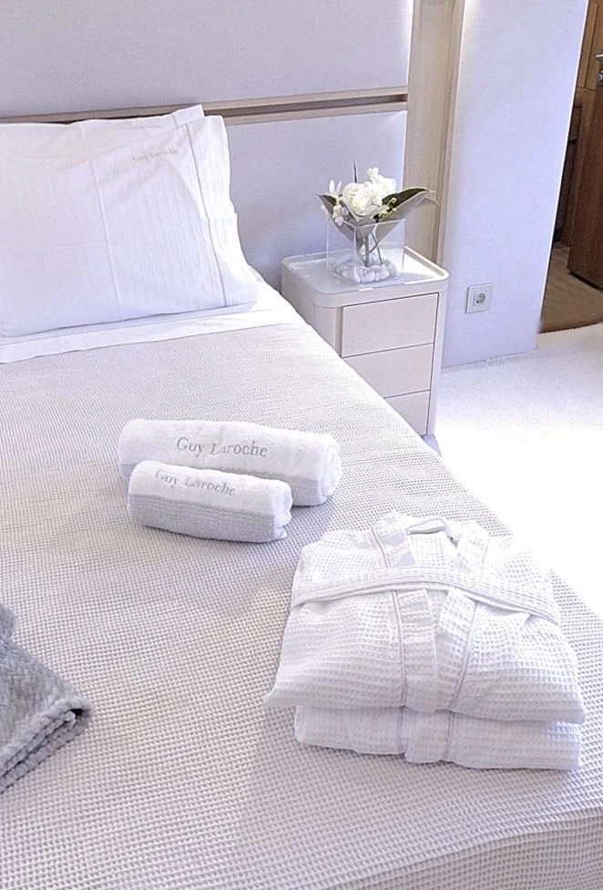 a folded white folded towel on a bed aboard FUNSEA Yacht for Sale