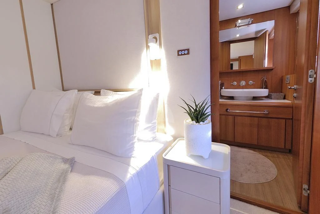 a bed with a white pillow and a white vase on it aboard FUNSEA Yacht for Sale