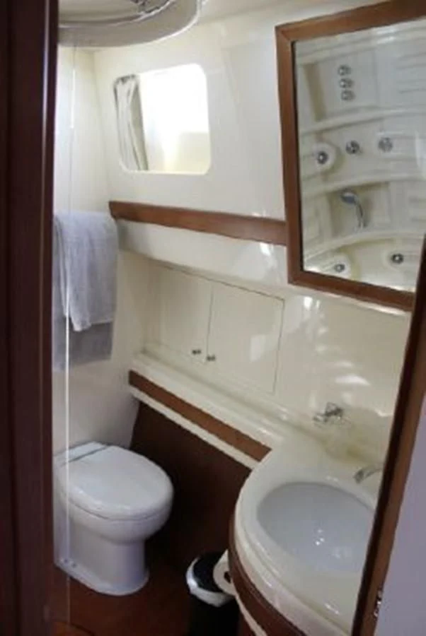 a bathroom with a toilet and a sink aboard PURA VIDA Yacht for Sale