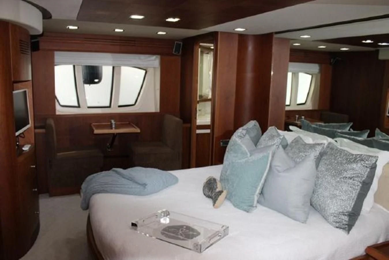 a bedroom with a bed and a chair aboard PURA VIDA Yacht for Sale