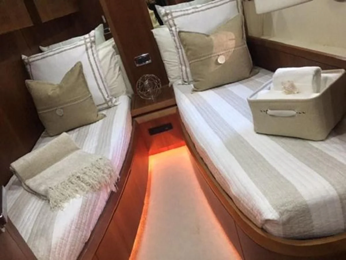 a room with a bed and a chair aboard PURA VIDA Yacht for Sale