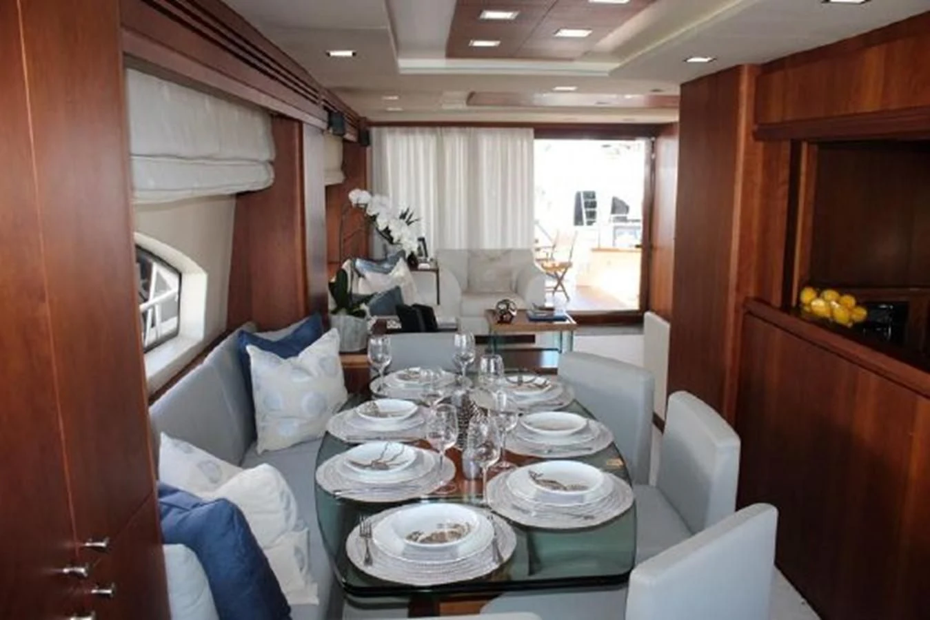 a dining table with plates and chairs aboard PURA VIDA Yacht for Sale
