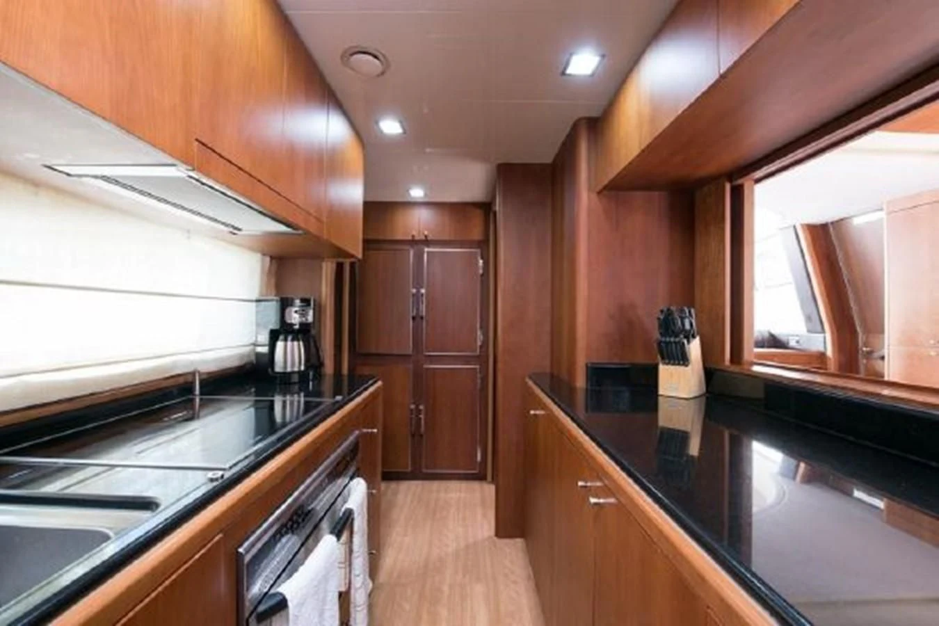 a kitchen with wooden cabinets aboard PURA VIDA Yacht for Sale