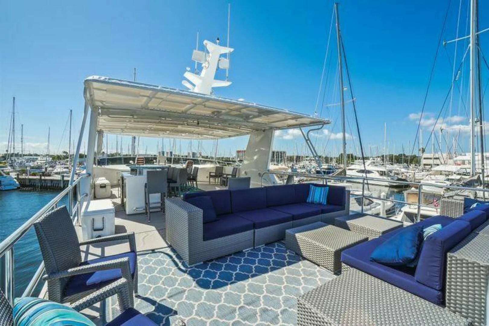 a patio with a lounge chair and a large white boat in the background aboard ISLAND SOUL Yacht for Sale