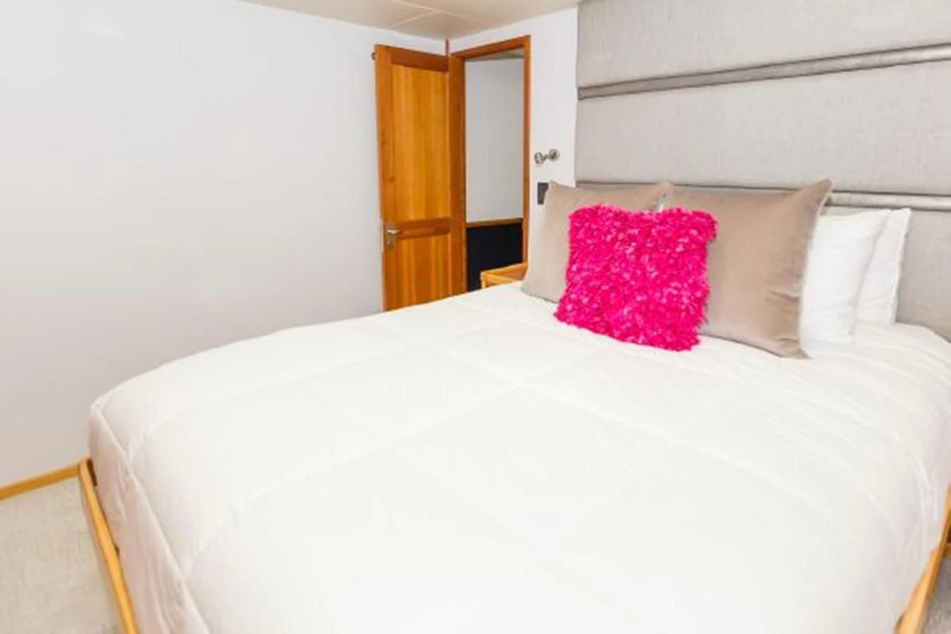 a bed with a white sheet and pink pillows aboard ISLAND SOUL Yacht for Sale