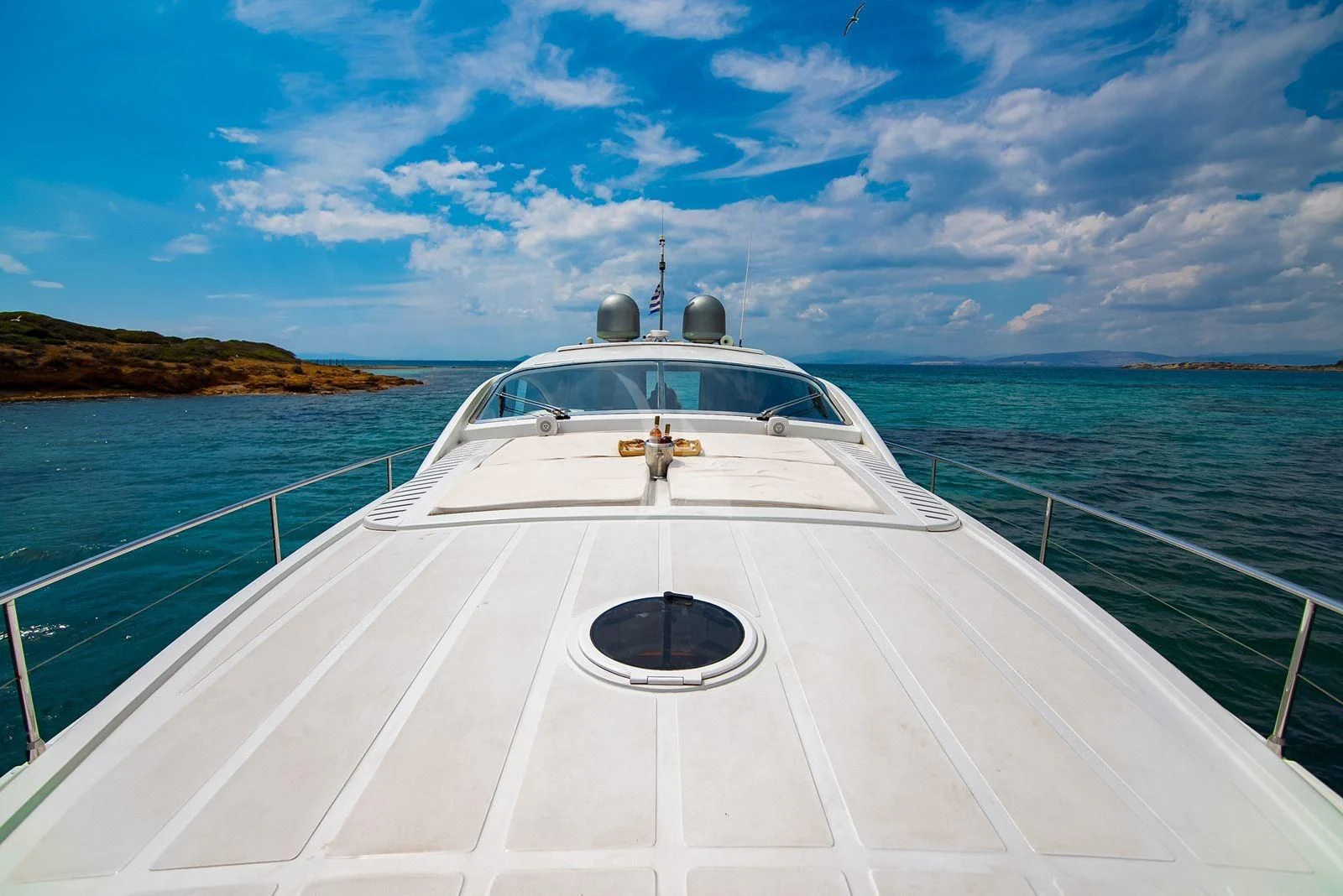 a white boat on a body of water aboard AXION Yacht for Charter