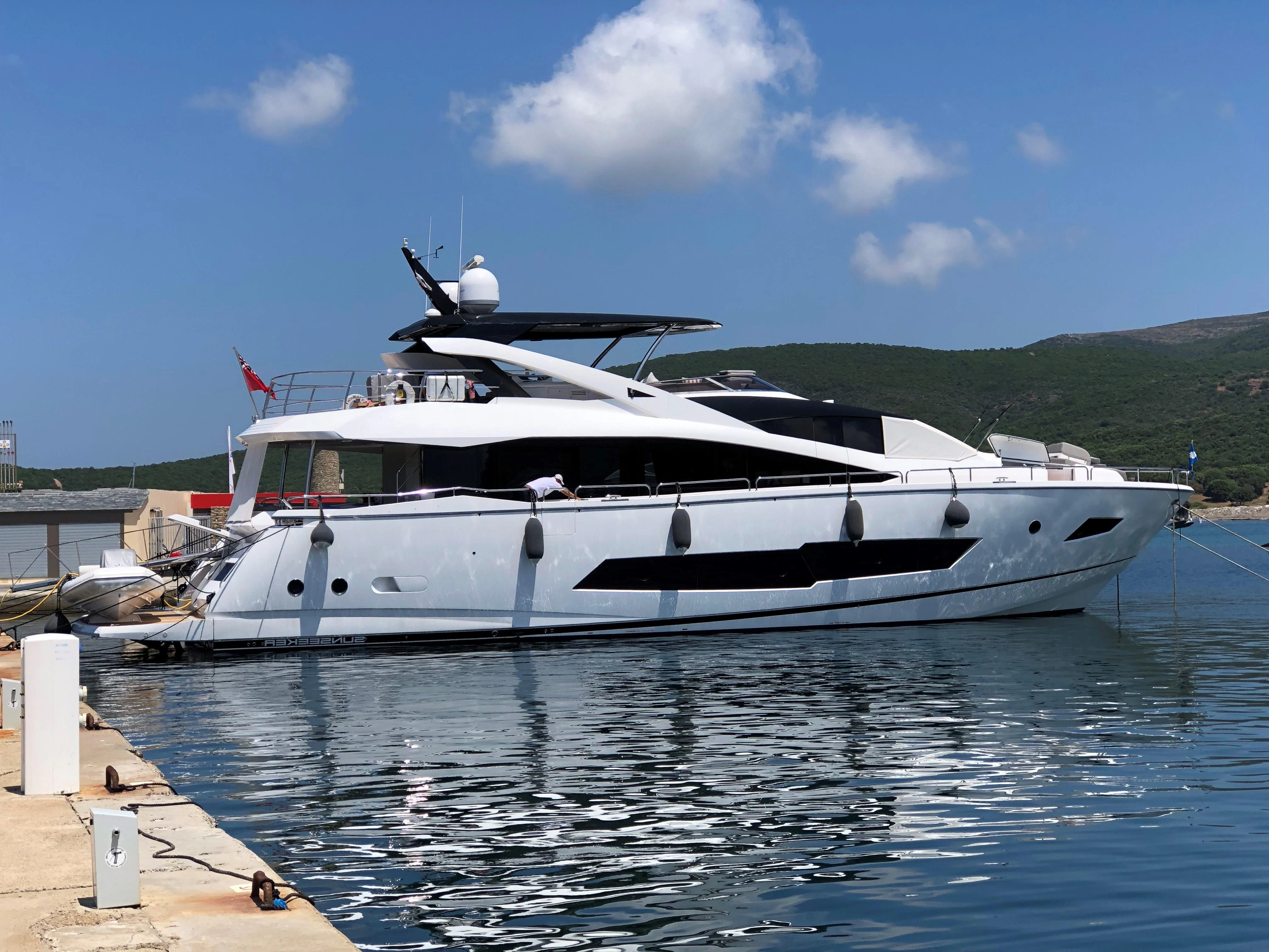 a white boat docked at a pier aboard RIANNA Yacht for Sale