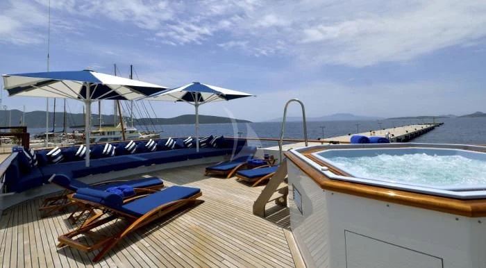 a deck with a pool and umbrellas on it aboard THE MERCY BOYS Yacht for Sale