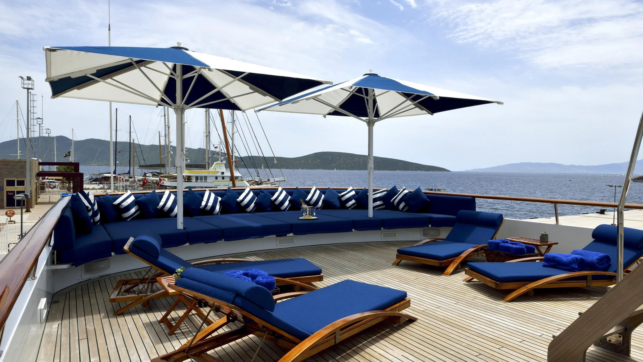 a deck with lounge chairs and umbrellas on it aboard THE MERCY BOYS Yacht for Sale